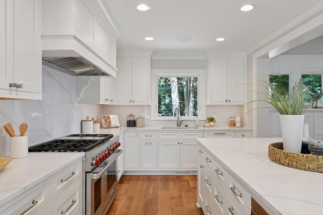 2462 Lafayette Rd, Minnetonka Beach, MN 55391 - kitchen with double oven range, white cabinets, light wood finished floors, recessed lighting, and light stone counters