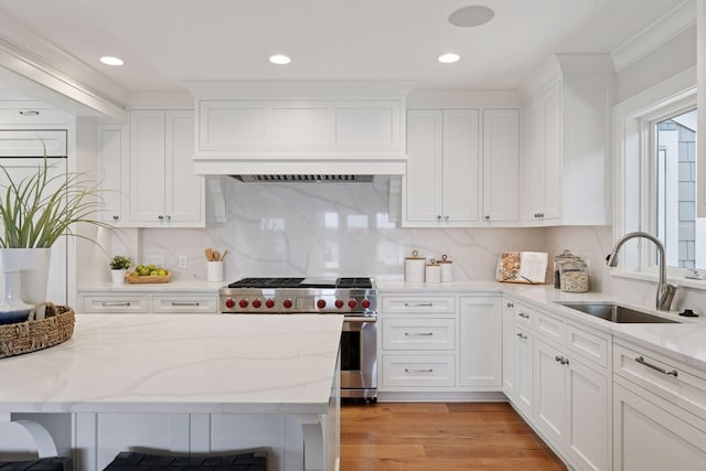 2462 Lafayette Rd, Minnetonka Beach, MN 55391 - kitchen with premium stove, white cabinetry, light stone counters, recessed lighting, and light wood finished floors