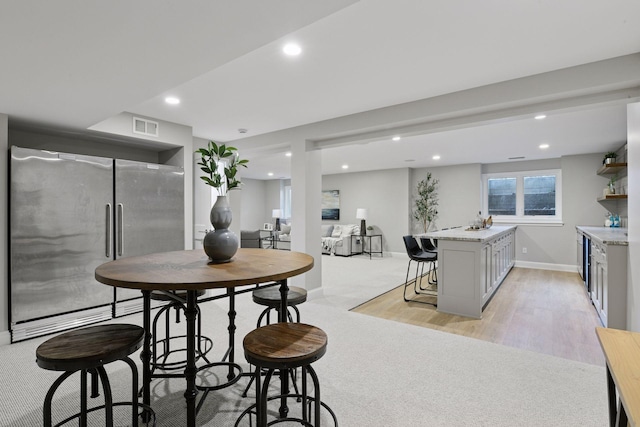 2462 Lafayette Rd, Minnetonka Beach, MN 55391 - dining area with wet bar, recessed lighting, light wood-style flooring, wine cooler, and light colored carpet
