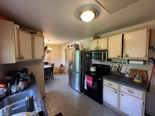 402 Grouse St, Sandstone, MN 55072 - kitchen with appliances with stainless steel finishes, dark countertops, a chandelier, a textured ceiling, and light tile patterned floors