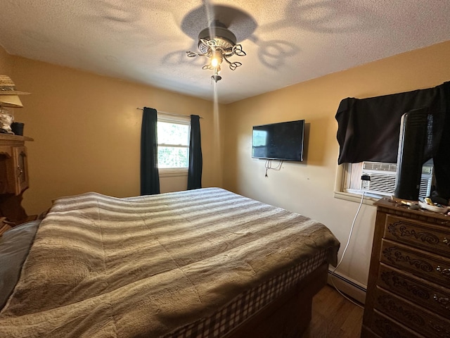 402 Grouse St, Sandstone, MN 55072 - bedroom featuring wood finished floors, a textured ceiling, ceiling fan, and a baseboard heating unit