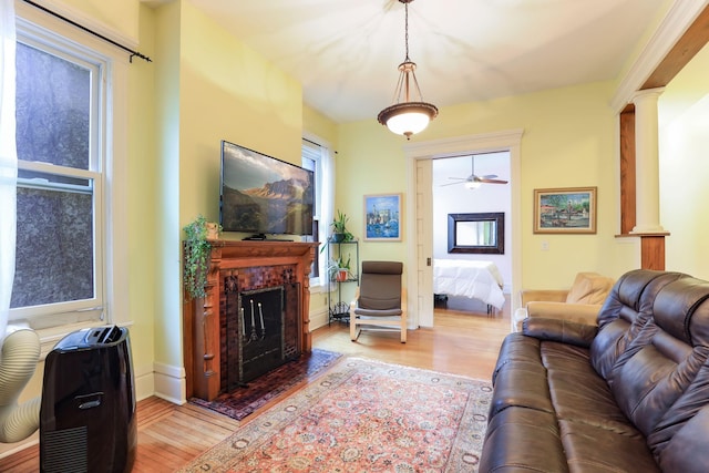1520 Elliot Ave Unit 4, Minneapolis, MN 55404 - living room featuring wood finished floors, ornate columns, a fireplace with flush hearth, and a ceiling fan