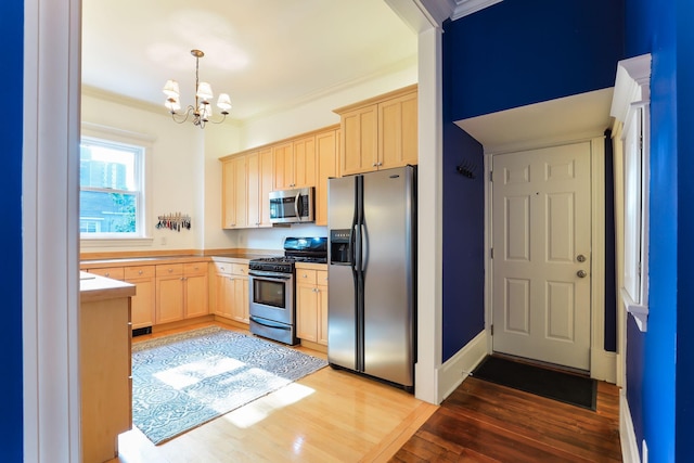 1520 Elliot Ave Unit 4, Minneapolis, MN 55404 - kitchen featuring appliances with stainless steel finishes, light brown cabinetry, a chandelier, light wood finished floors, and crown molding