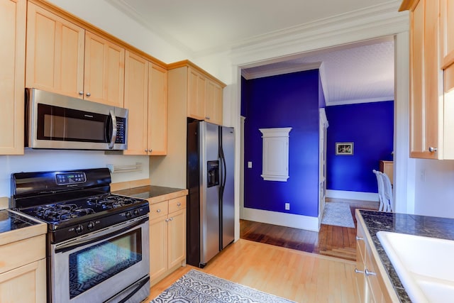 1520 Elliot Ave Unit 4, Minneapolis, MN 55404 - kitchen with stainless steel appliances, light wood-style flooring, dark countertops, and crown molding