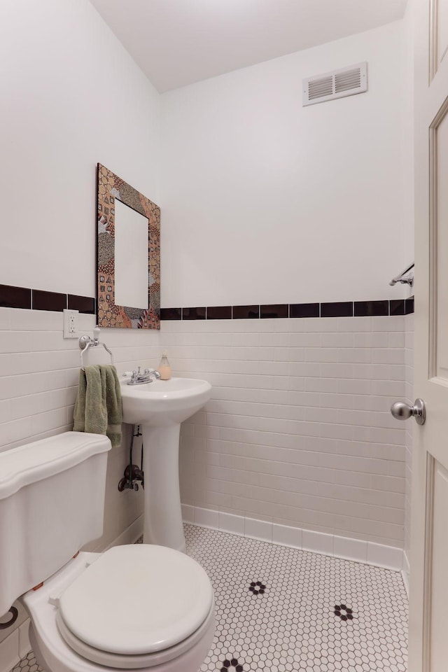 1520 Elliot Ave Unit 4, Minneapolis, MN 55404 - bathroom with tile walls, a wainscoted wall, and tile patterned floors