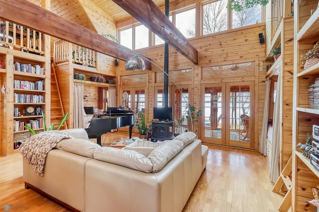 12104 County Highway 17, Lake View Twp, MN 56501 - living room featuring french doors, wooden walls, high vaulted ceiling, a wood stove, and wood-type flooring