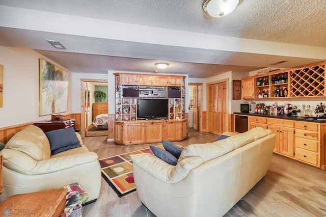 12104 County Highway 17, Lake View Twp, MN 56501 - living area with bar, light wood-style flooring, and a textured ceiling
