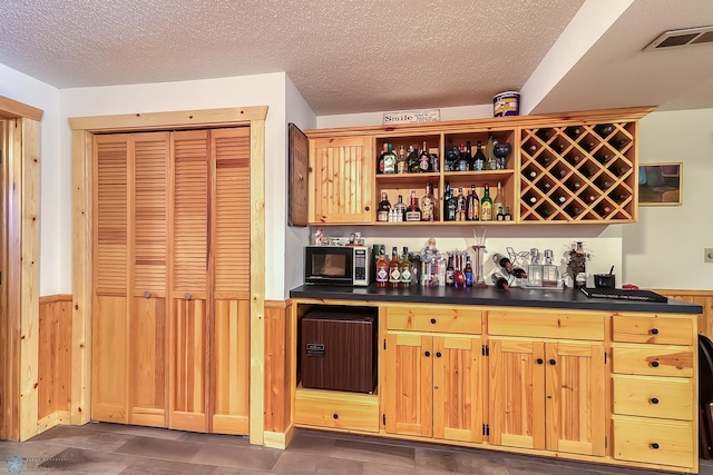 12104 County Highway 17, Lake View Twp, MN 56501 - indoor wet bar featuring a wainscoted wall, a textured ceiling, and wooden walls