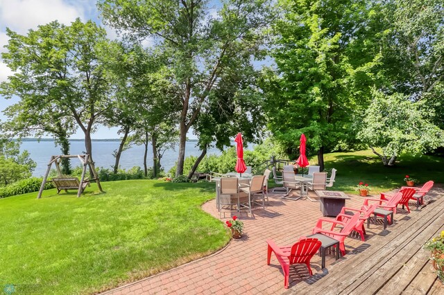 12104 County Highway 17, Lake View Twp, MN 56501 - view of grassy yard with a deck with water view, outdoor dining space, and a fire pit