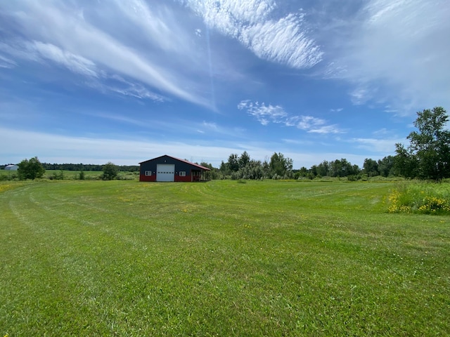 20668 County Road 41, Bremen Twp, MN 55795 - view of green lawn featuring a garage, a view of rural / pastoral area, driveway, and an outdoor structure