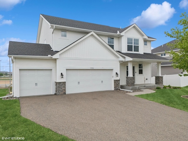 15742 Everglade Ave, Apple Valley, MN 55124 - view of front of property with stone siding, covered porch, driveway, and a garage