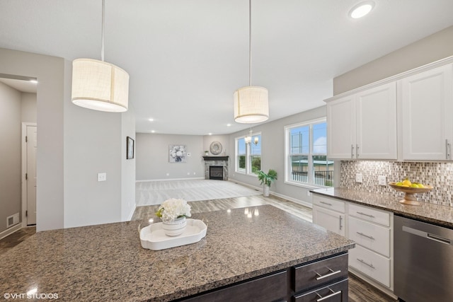 15742 Everglade Ave, Apple Valley, MN 55124 - kitchen featuring stainless steel dishwasher, light stone counters, white cabinetry, tasteful backsplash, and decorative light fixtures