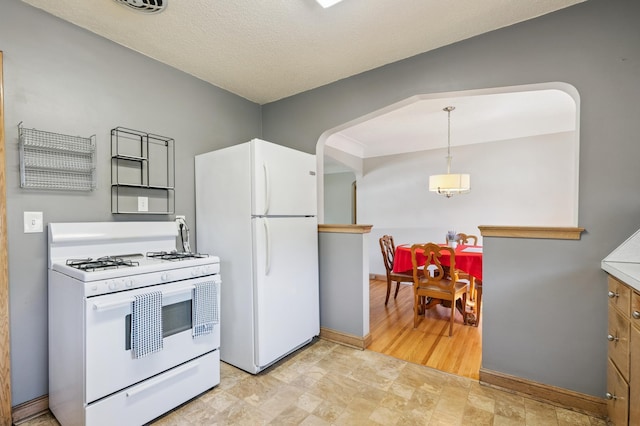 3355 Central Ave NE, Minneapolis, MN 55418 - kitchen with white appliances, stone finish floors, hanging light fixtures, and arched walkways