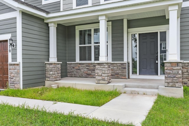 5370 Fountain Ln N, Plymouth, MN 55446 - view of exterior entry with a porch, stone siding, and a garage