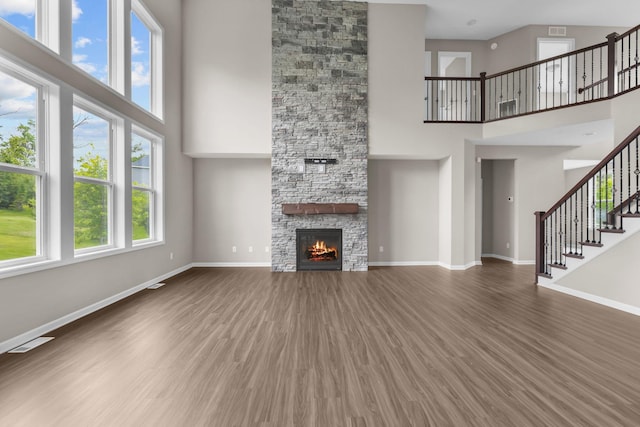 5370 Fountain Ln N, Plymouth, MN 55446 - unfurnished living room with a high ceiling, wood finished floors, stairway, and a stone fireplace