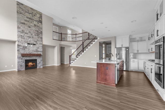 5370 Fountain Ln N, Plymouth, MN 55446 - kitchen with open floor plan, appliances with stainless steel finishes, light countertops, a kitchen island with sink, and a fireplace