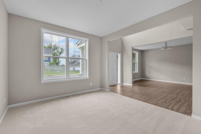 5370 Fountain Ln N, Plymouth, MN 55446 - spare room with carpet floors, a chandelier, and wood finished floors