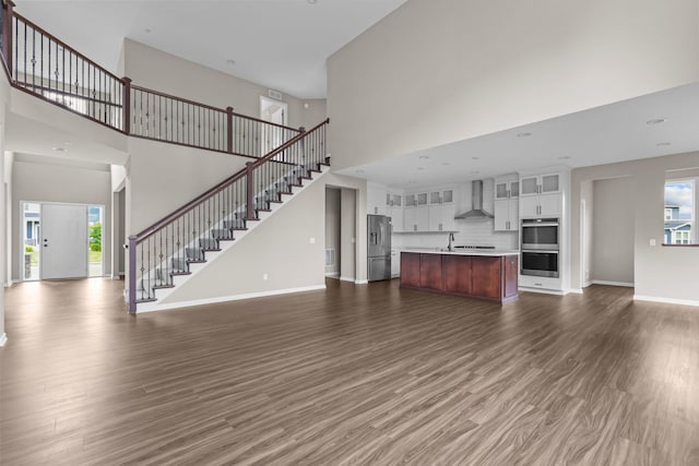 5370 Fountain Ln N, Plymouth, MN 55446 - unfurnished living room with a towering ceiling, dark wood-style flooring, and stairs