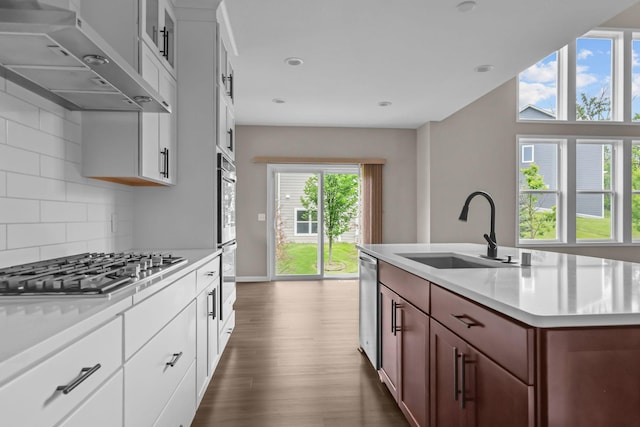 5370 Fountain Ln N, Plymouth, MN 55446 - kitchen with exhaust hood, appliances with stainless steel finishes, light countertops, backsplash, and dark wood-style floors