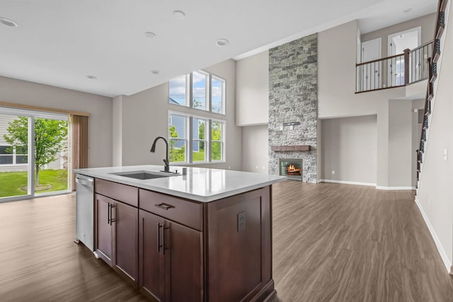 5370 Fountain Ln N, Plymouth, MN 55446 - kitchen featuring wood finished floors, a high ceiling, light countertops, dishwasher, and a stone fireplace