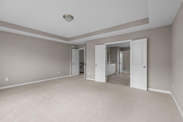 5370 Fountain Ln N, Plymouth, MN 55446 - unfurnished bedroom with light carpet, a tray ceiling, and ensuite bathroom