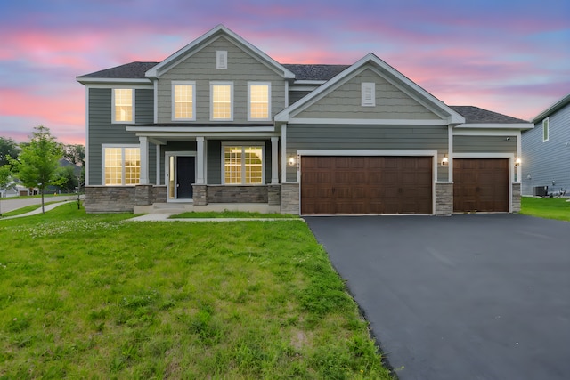 5390 Everest Ln N, Plymouth, MN 55446 - view of front facade featuring an attached garage, stone siding, driveway, and a front yard