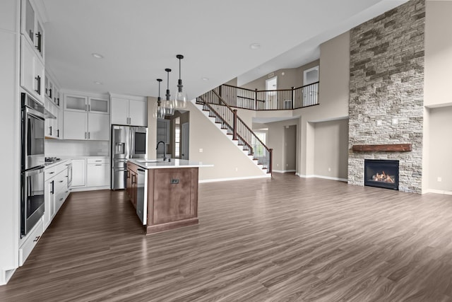 5390 Everest Ln N, Plymouth, MN 55446 - kitchen featuring open floor plan, stainless steel appliances, light countertops, dark wood-style flooring, and a towering ceiling