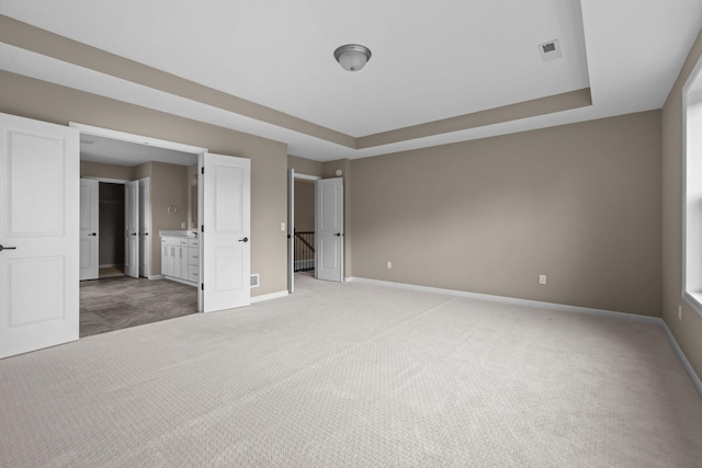 5390 Everest Ln N, Plymouth, MN 55446 - unfurnished bedroom with light carpet, a raised ceiling, and connected bathroom