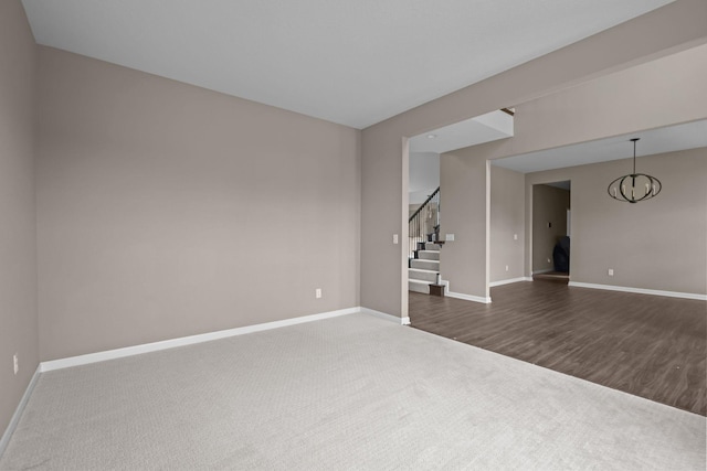 5390 Everest Ln N, Plymouth, MN 55446 - unfurnished room featuring stairway, a chandelier, dark carpet, and dark wood finished floors