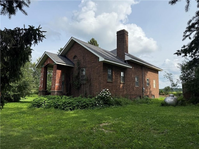 2999 18th St, Oak Grove Twp, WI 54868 - view of side of home featuring a chimney, a yard, and brick siding