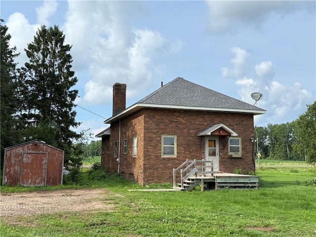 2999 18th St, Oak Grove Twp, WI 54868 - rear view of house with a chimney, a shed, a lawn, and brick siding