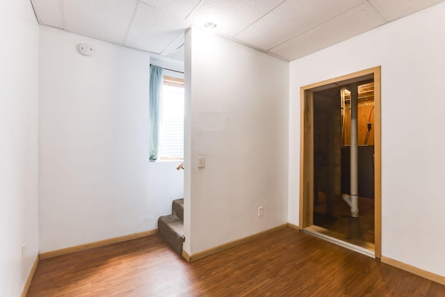2707 Girard Ave N, Minneapolis, MN 55411 - empty room featuring a paneled ceiling, wood finished floors, stairway, and a smoke detector