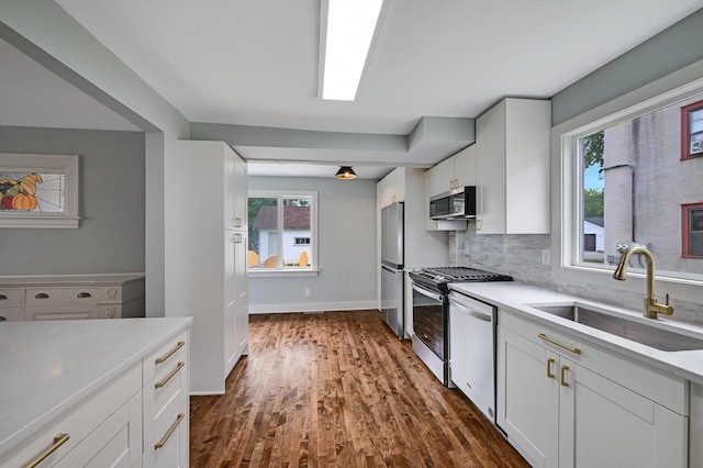 4416 46th Ave S, Minneapolis, MN 55406 - kitchen featuring stainless steel appliances, dark wood-type flooring, white cabinets, and tasteful backsplash