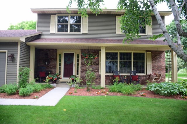 15620 45th Ave N, Plymouth, MN 55446 - traditional-style home with a porch, brick siding, a front yard, and a garage