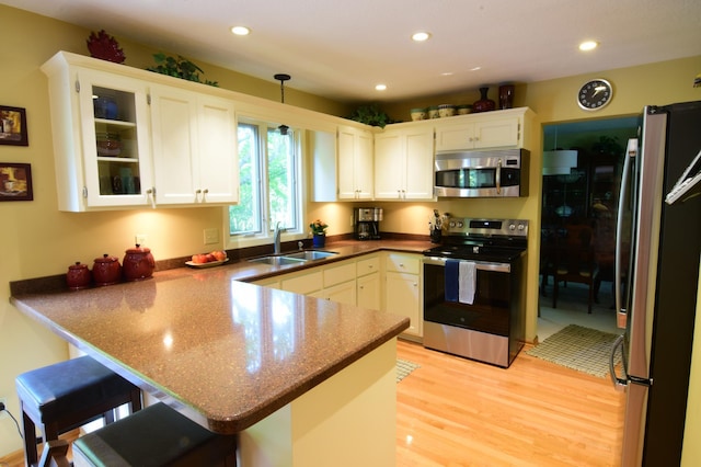 15620 45th Ave N, Plymouth, MN 55446 - kitchen with appliances with stainless steel finishes, a peninsula, light wood finished floors, white cabinets, and recessed lighting