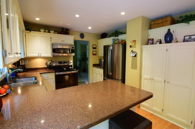 15620 45th Ave N, Plymouth, MN 55446 - kitchen with appliances with stainless steel finishes, a peninsula, recessed lighting, a breakfast bar area, and white cabinets