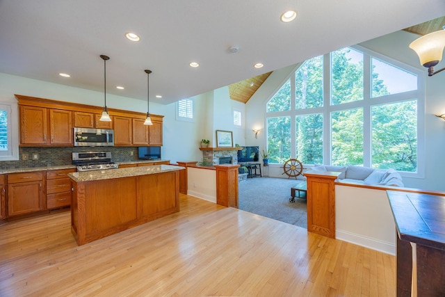 5108 Drummond Rd, Mound, MN 55364 - kitchen featuring stainless steel appliances, open floor plan, brown cabinetry, a kitchen island, and light wood-type flooring