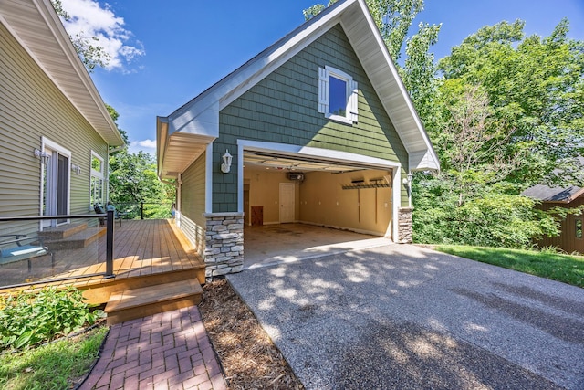 5108 Drummond Rd, Mound, MN 55364 - view of front of home with stone siding, a wooden deck, a garage, and an outdoor structure
