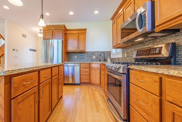 5108 Drummond Rd, Mound, MN 55364 - kitchen with stainless steel appliances, light wood-style floors, brown cabinets, backsplash, and recessed lighting