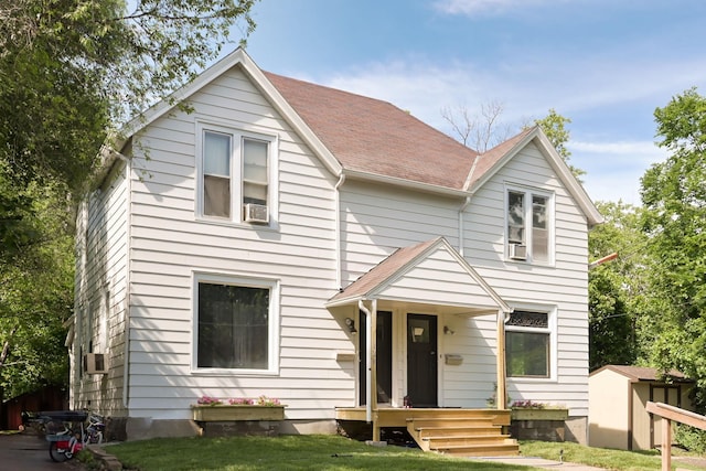 129 Morton St E, Saint Paul, MN 55107 - view of front of property with a shed, a front yard, a shingled roof, and cooling unit