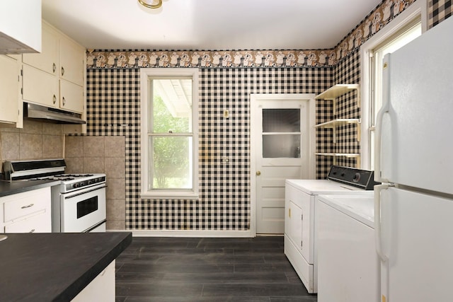 129 Morton St E, Saint Paul, MN 55107 - kitchen with white appliances, under cabinet range hood, separate washer and dryer, dark wood-type flooring, and dark countertops