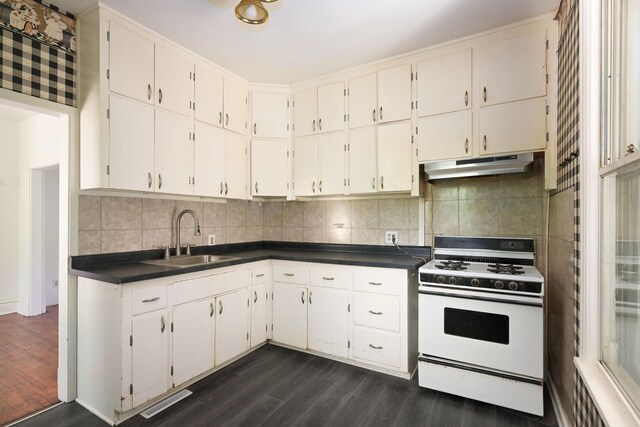 129 Morton St E, Saint Paul, MN 55107 - kitchen featuring white gas range oven, under cabinet range hood, dark wood-style flooring, and dark countertops