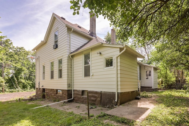 129 Morton St E, Saint Paul, MN 55107 - view of side of property featuring a chimney, roof with shingles, and entry steps