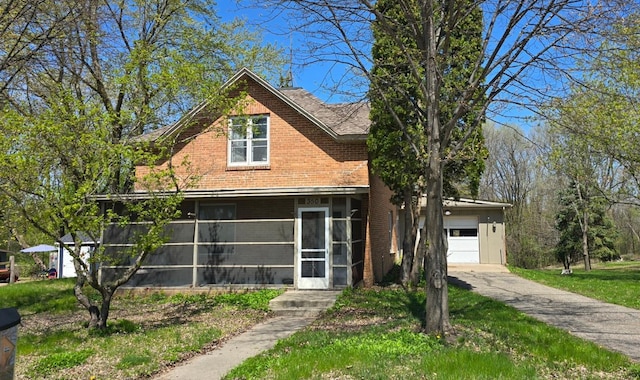 350 Harrison St W, Annandale, MN 55302 - view of front of house with concrete driveway, brick siding, a sunroom, and a garage