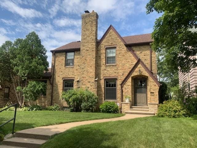 5504 Elliot Ave, Minneapolis, MN 55417 - tudor-style house with a front yard, a chimney, and brick siding