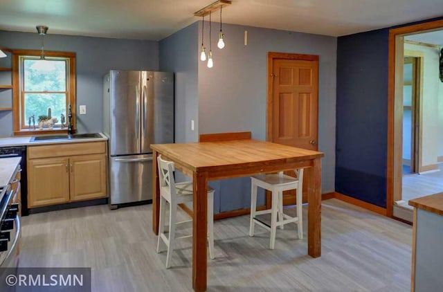 1217 83rd Ave, Lincoln Twp, WI 54001 - kitchen featuring freestanding refrigerator, light wood-style floors, hanging light fixtures, and light brown cabinetry