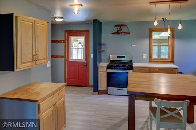 1217 83rd Ave, Lincoln Twp, WI 54001 - kitchen with stainless steel gas range, wood counters, light wood-style floors, light brown cabinetry, and hanging light fixtures