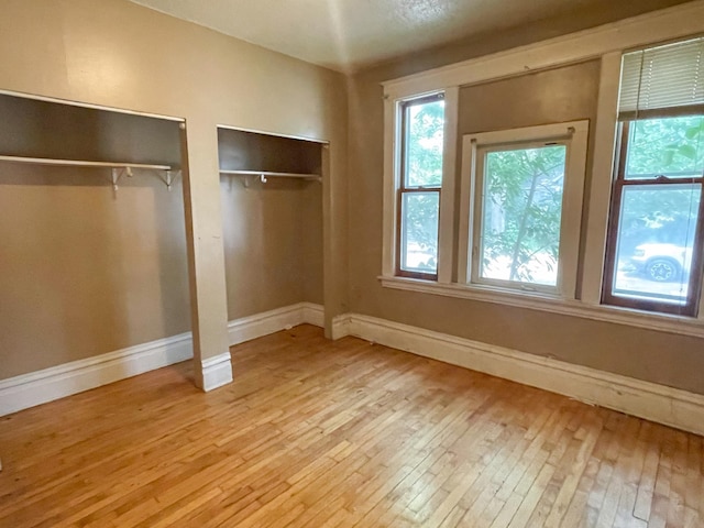 629 Farrington St, Saint Paul, MN 55103 - unfurnished bedroom featuring two closets and hardwood / wood-style flooring