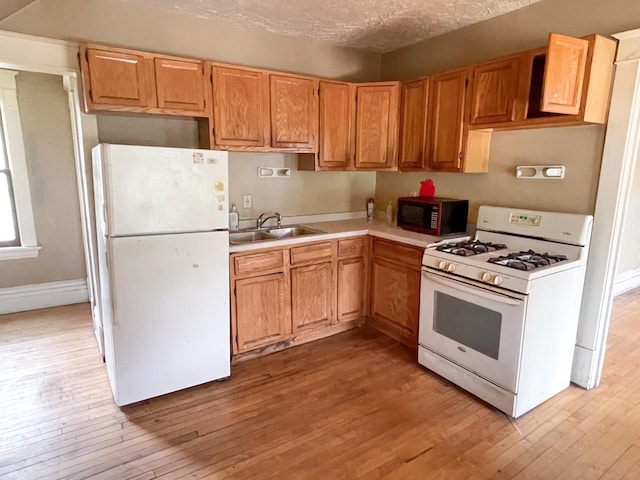 629 Farrington St, Saint Paul, MN 55103 - kitchen featuring white appliances, light wood-type flooring, light countertops, and a textured ceiling