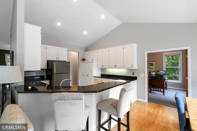 13840 Edenwood Way, Apple Valley, MN 55124 - kitchen featuring freestanding refrigerator, a peninsula, dark countertops, white cabinets, and recessed lighting